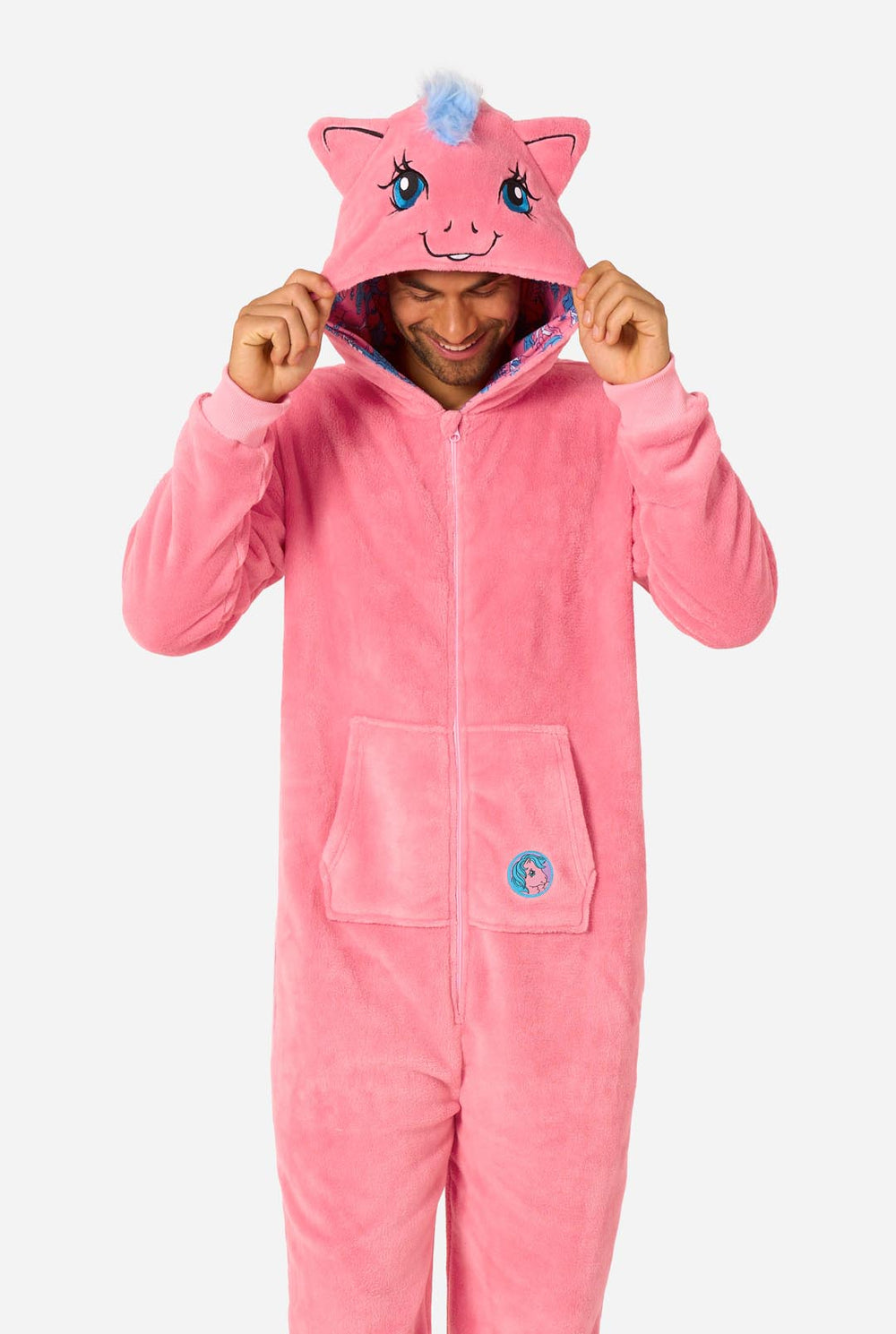 Man wearing a pink onesie with a My Little Pony design on a light background. Hood up
