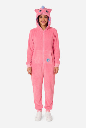 Woman wearing a pink onesie with a My Little Pony design on a light background. Full body image.