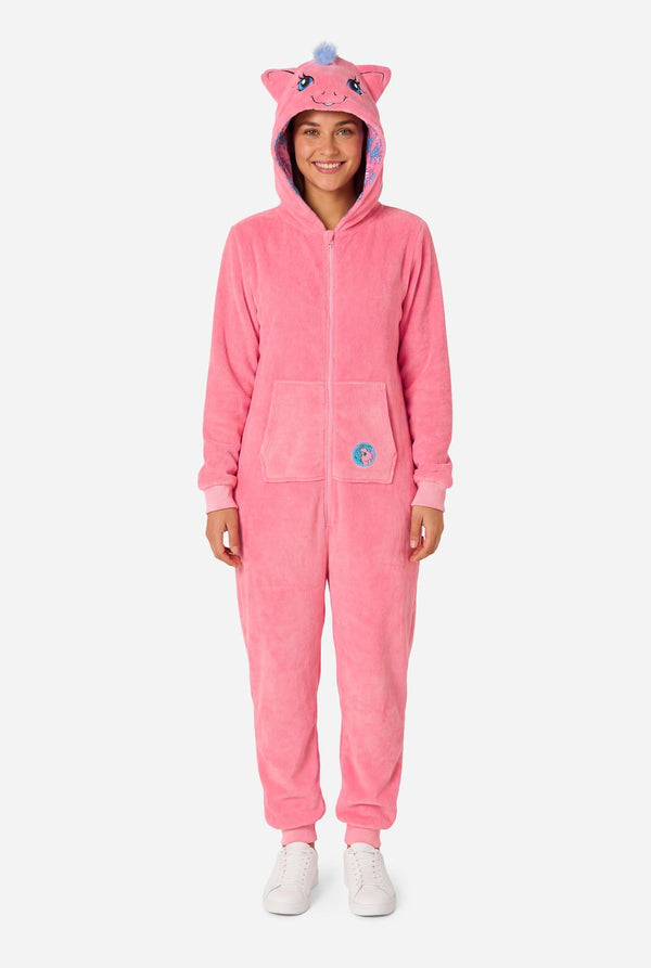 Woman wearing a pink onesie with a My Little Pony design on a light background. Full body image.