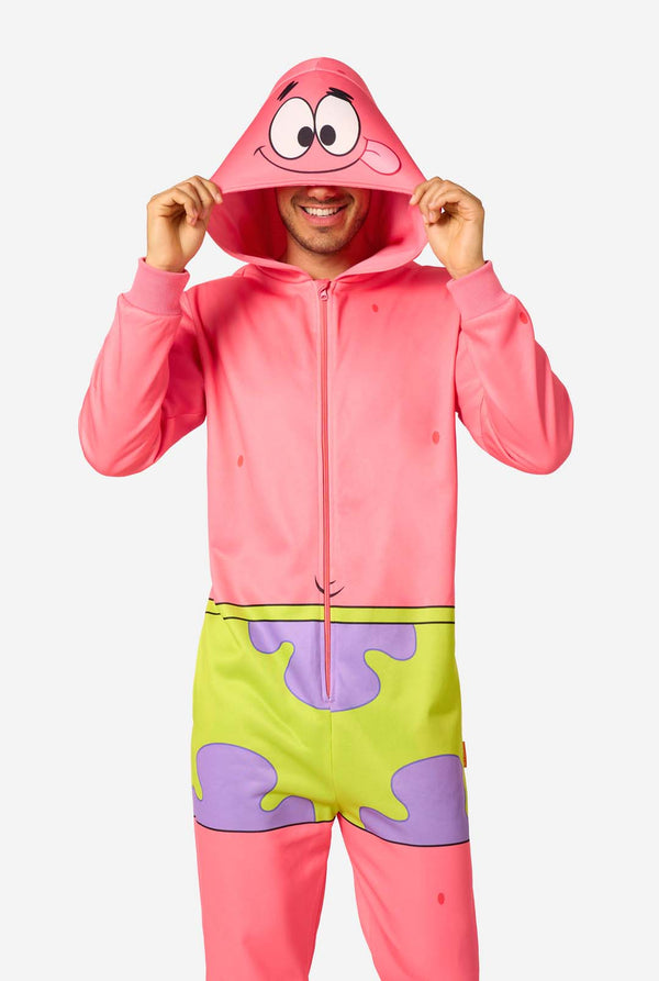 Adult wearing a pink Patrick Star onesie with a front zipper, green shorts design, and a hood featuring Patrick’s face, holding the hood edges.
