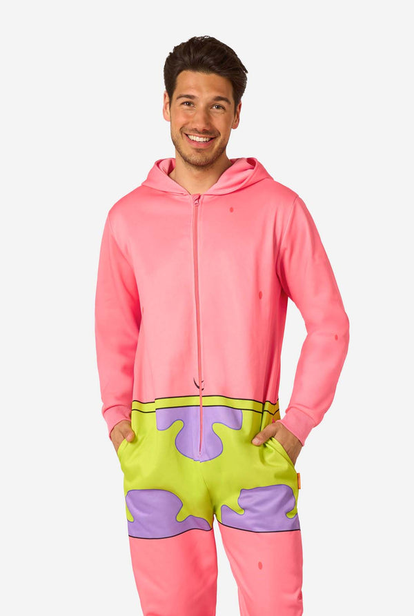 Front view of an adult wearing a pink Patrick Star onesie with a hood down, green and purple shorts pattern, and hands in the pockets.