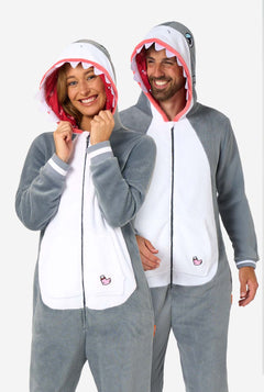 Two people wearing shark-themed onesies on a white background