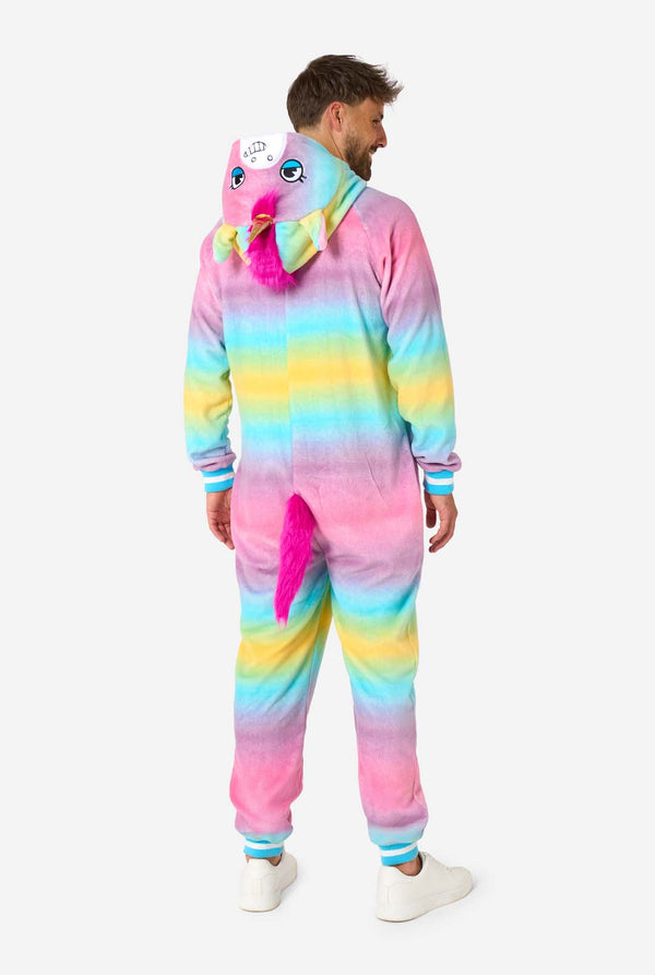 A man wearing a colorful adult onesie designed as a rainbow unicorn. The onesie features a vibrant gradient of pastel colors, a golden horn, and playful unicorn details, perfect for cozy lounging or costume parties. The hood is lying flat on his back. View from the back.