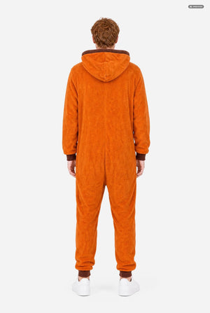 A smiling man wearing an orange South Park Kenny onesie with brown drawstrings and cuffs, standing against a light gray background. A small patch on the left leg reads 'South Park'.  View from the back.