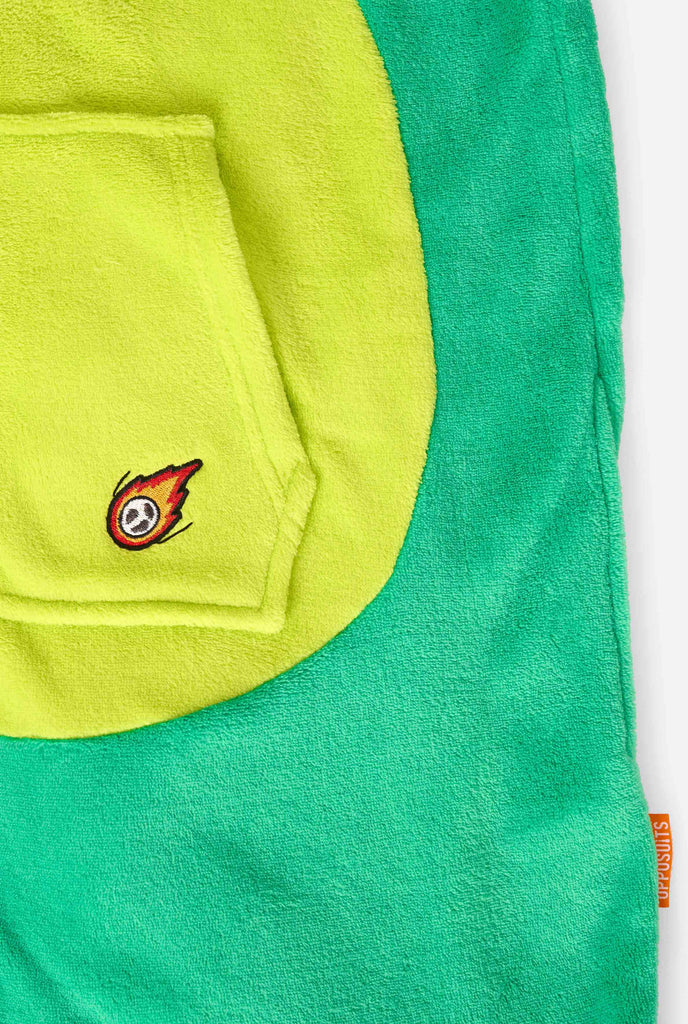 A kid is wearing a green dinosaur kids onesie featuring playful hood details and cozy, soft material, perfect for lounging or costume events. Focused on the pockets.