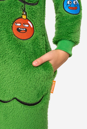 Close-up of the green plush Christmas tree onesie showing an ornament patch, front pocket, and orange OppoSuits label.