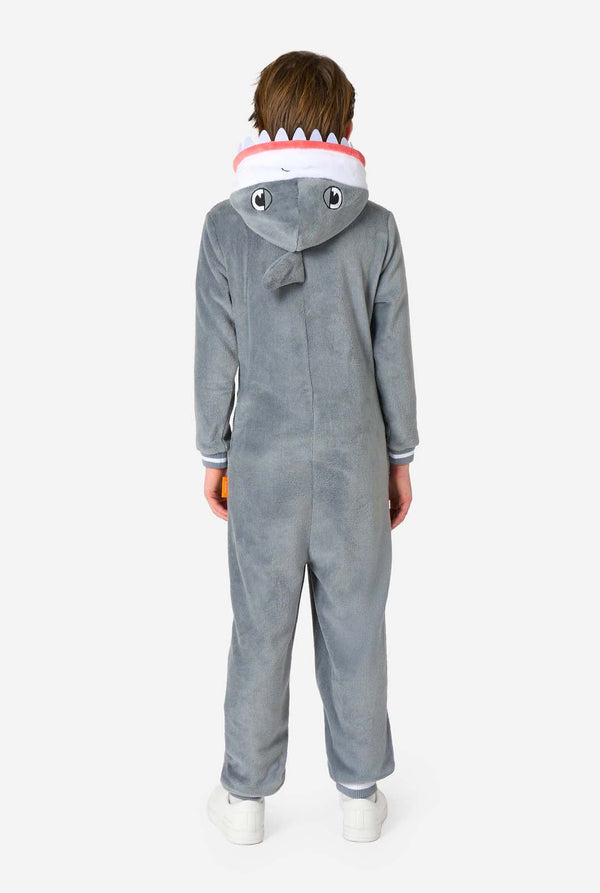 Back view of a child wearing a grey shark onesie with embroidered eyes, small dorsal fin, and tail fin detail on the hood.