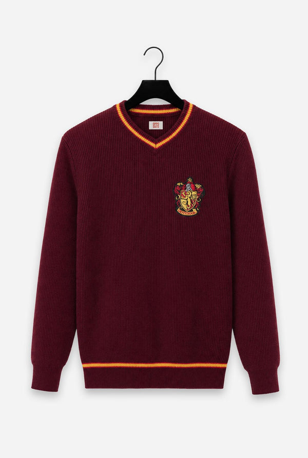 A maroon ribbed knit V-neck Harry Potter Gryffindor sweater with orange trim and a embroidered Gryffindor crest on the left chest, hanging on a black hanger against a light gray background.