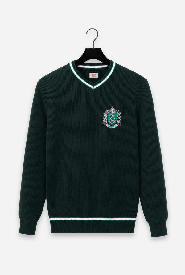 A dark green ribbed knit Harry Potter Slytherin sweater with white trim on a black hanger against a light gray background. The sweater features a V-neck, a Slytherin crest embroidered on the left chest, and white stripes on the collar, hem, and cuffs.