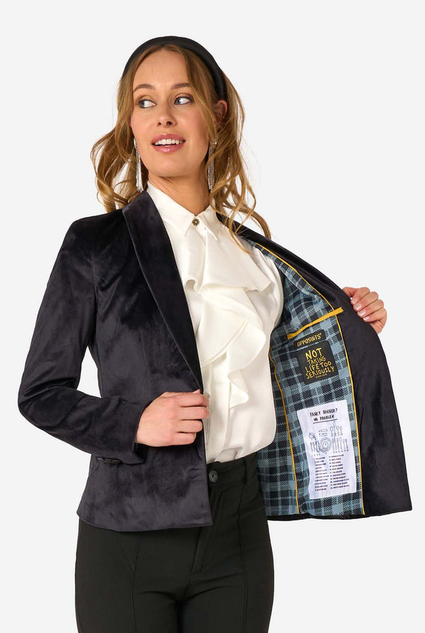 Woman wearing a black blazer with a plaid lining, holding it open to reveal the inside.
