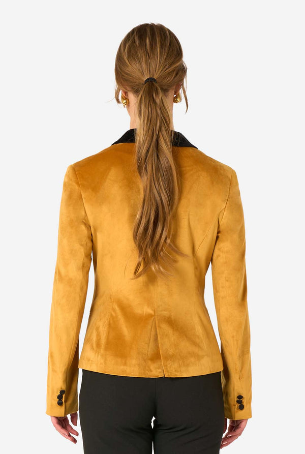 Woman wearing a velvet golden blazer with black lapels on a white background, view from the back.