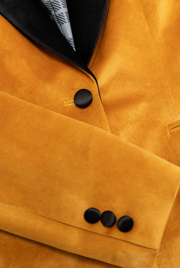 Woman wearing golden velvet dinner jacket blazer, close up