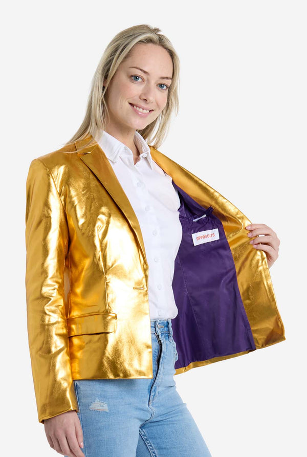 Woman wearing a gold jacket with a purple lining, standing against a white background