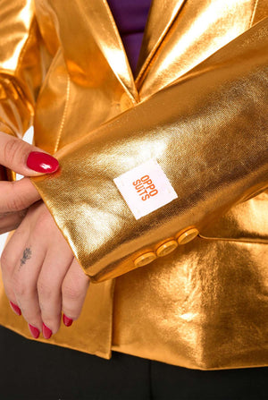 Gold blazer with a brand label held by a hand