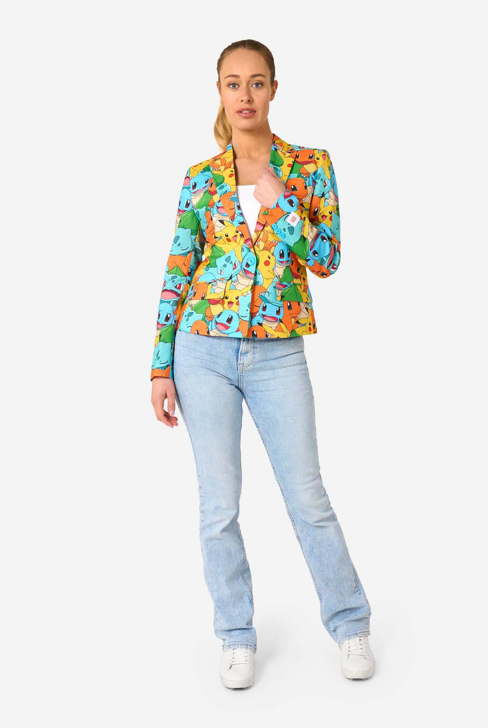 Women wearing a multi colored pokemon blazer, featuring characters such as pikachu, squirtle, charmander and bulbasaur. Holding the jacket and smiling in the camera.