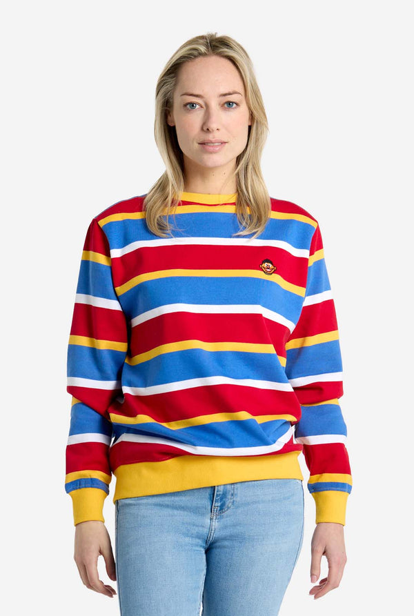 Woman wearing a colorful striped sweater with a plain background