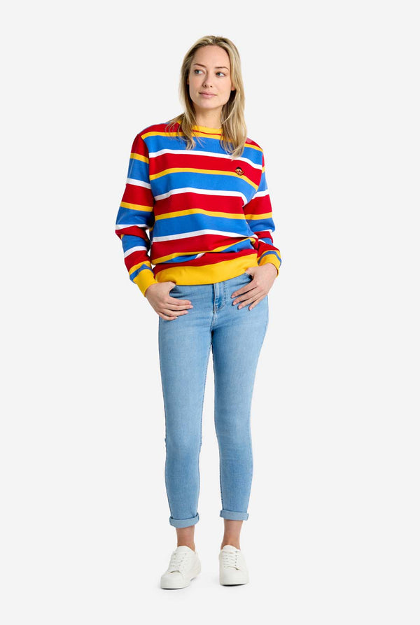 Person wearing a colorful striped sweater and light blue jeans on a white background