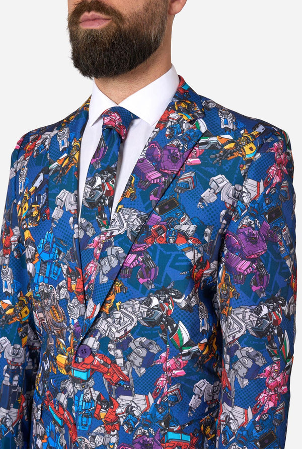 Man wearing a colorful suit with Transformer pattern on a light background. Chest close-up.