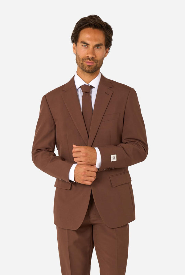Man wearing a solid brown suit with a white shirt and matching brown tie, shown from the waist up against a white background.