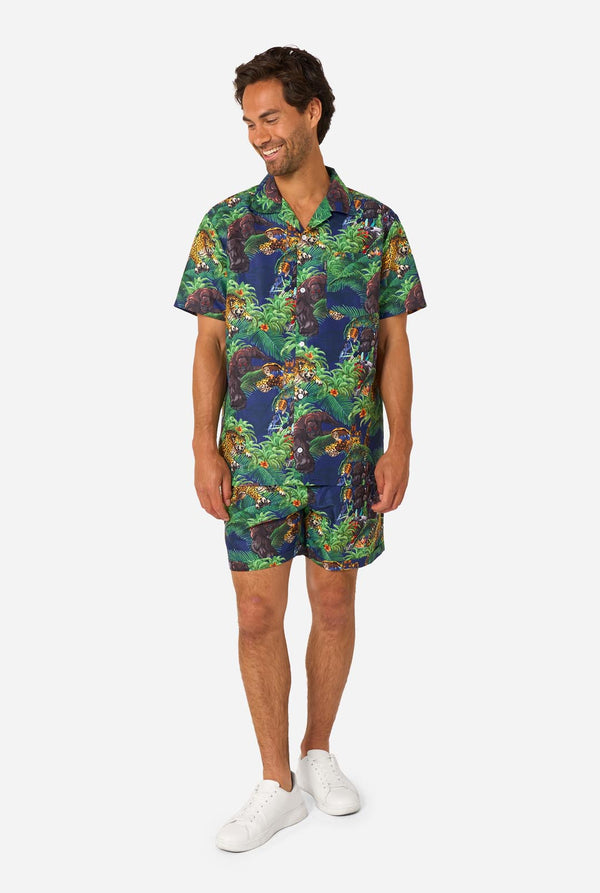 Man wearing a colorful tropical Transformers animal print summer set on a light background. Full body image.