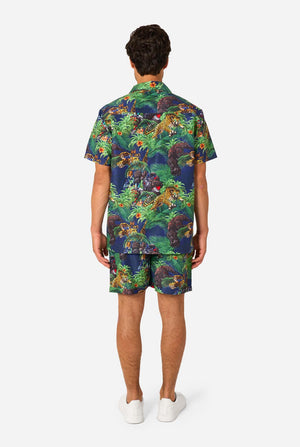 Man wearing a colorful tropical Transformers animal print summer set on a light background. View from the back.