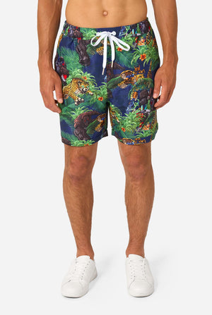 Man wearing a colorful tropical Transformers animal print summer set on a light background. Close up on shorts.