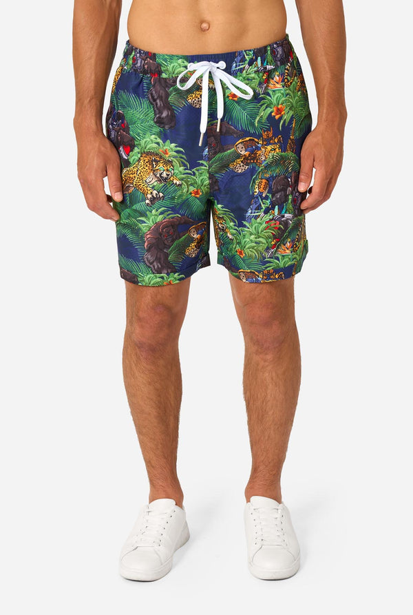Man wearing a colorful tropical Transformers animal print summer set on a light background. Close up on shorts.