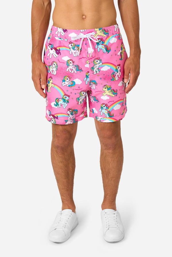 Man wearing pink summer set with My Little Pony and rainbow pattern on a light background. Shorts view.