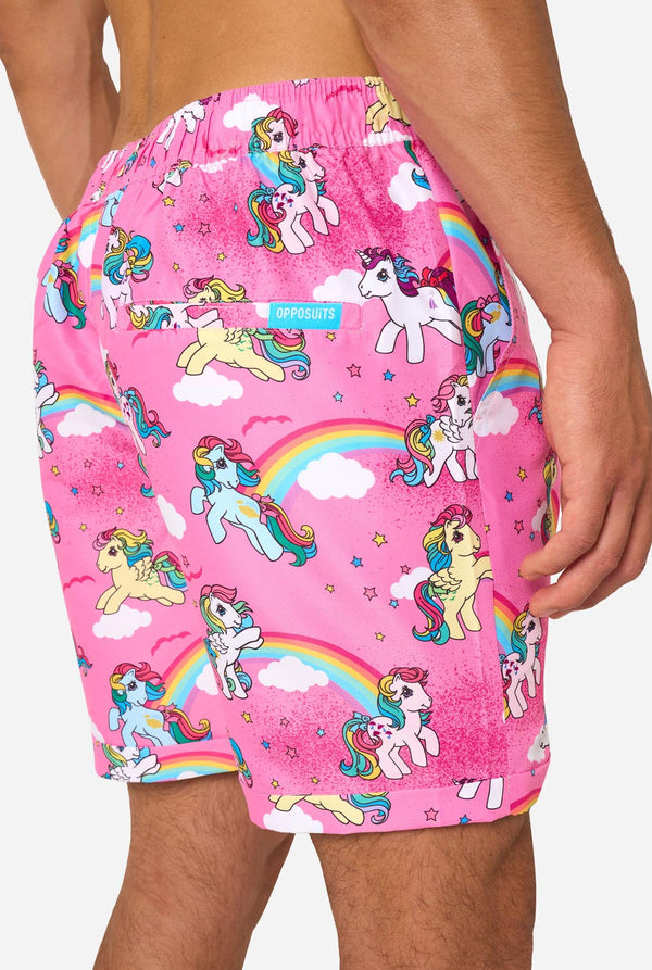 Man wearing pink summer set with My Little Pony and rainbow pattern on a light background. Shorts close-up.