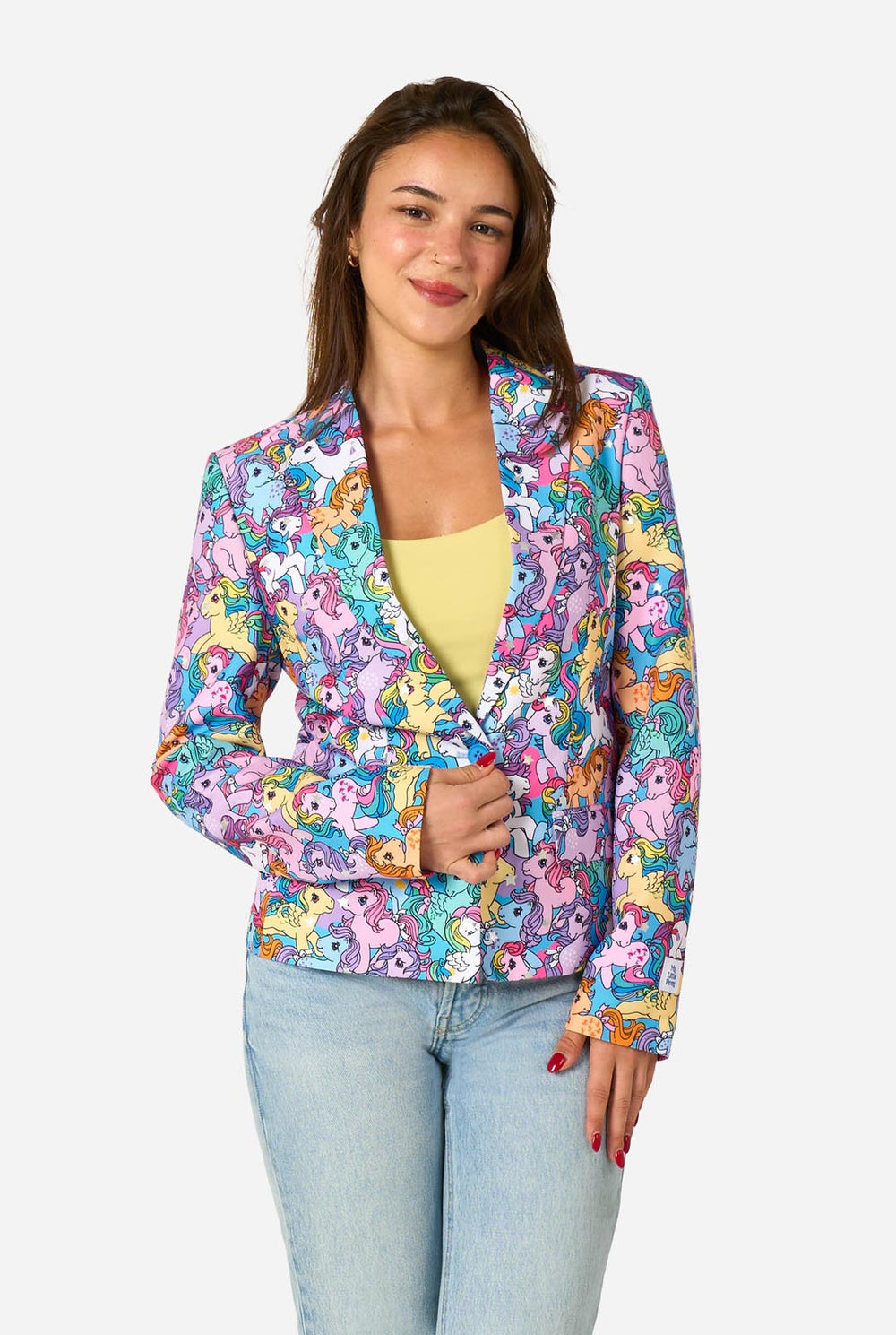 Woman wearing a colorful patterned My Little Pony blazer on a light background.