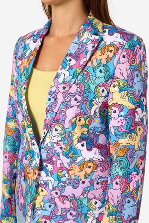 Woman wearing a colorful patterned My Little Pony blazer on a light background. Chest close-up.