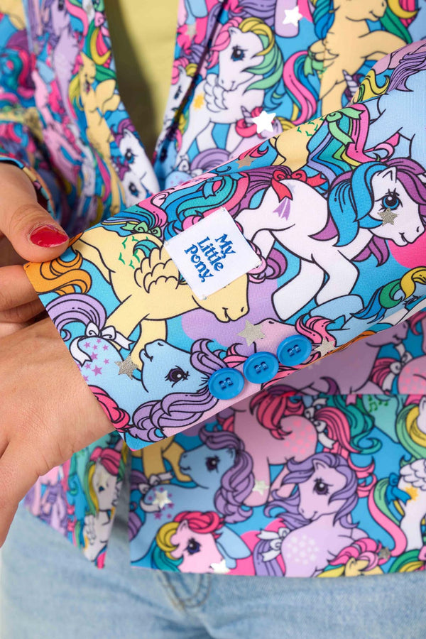 Woman wearing a colorful patterned My Little Pony blazer on a light background. Sleeve close up.