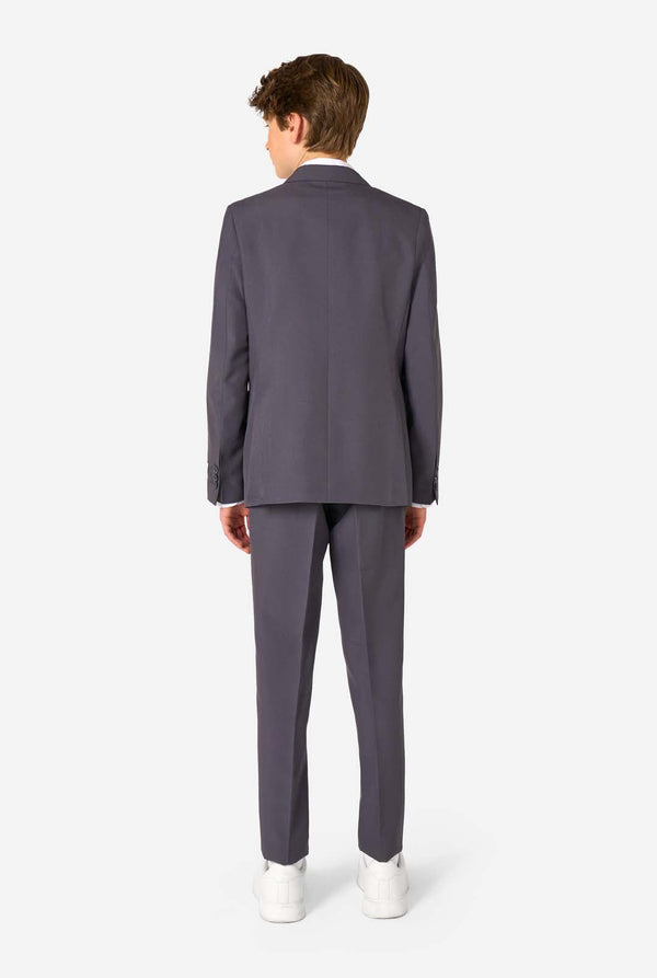 Teen boy wearing a stylish charcoal colored grey suit with a white dress shirt, smiling confidently. Perfect formal outfit for boys' special occasions, weddings, and parties. View from the back.