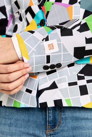 Person holding a deck of playing cards with geometric pattern and visible brand logo.