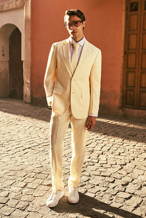 Full body image of a man in a pastellow suit