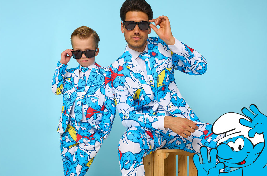 This is an image with a light blue background with a Smurf on the bottom left and a man and kid wearing a suit with an all-over Smurf suit. The man and kid are also wearing sunglasses.