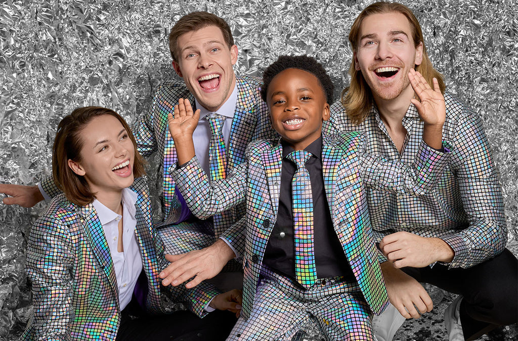 Image with an aluminum foil background and 4 people wearing an OppoSuits discoballer outfit. 3 adults and a kid. 