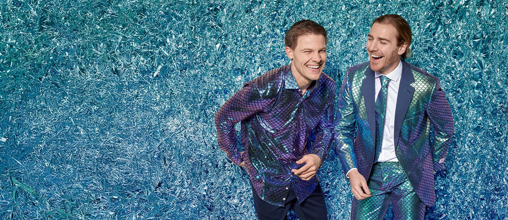 Image with blue foil background and two men laughing wearing OppoSuits outfits. One man is wearing a blue fish scale shirt and the other is wearing a blue fish scale suit with a with shirt.