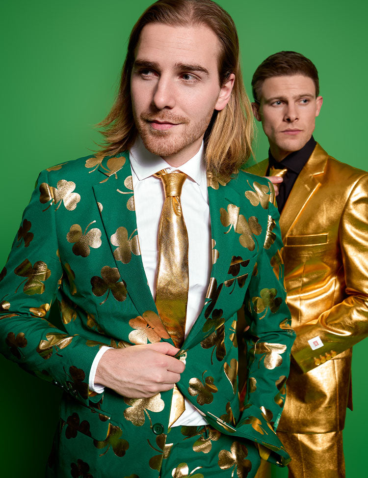 Image with green background and on the left a man wearing a green suit with golden clovers and on the right a man wearing a golden suit.