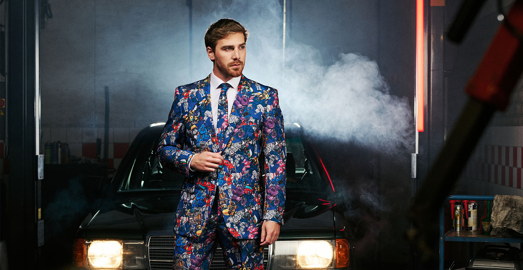 Image of garage with a car and a man wearing the OppoSuits Transformers suit.