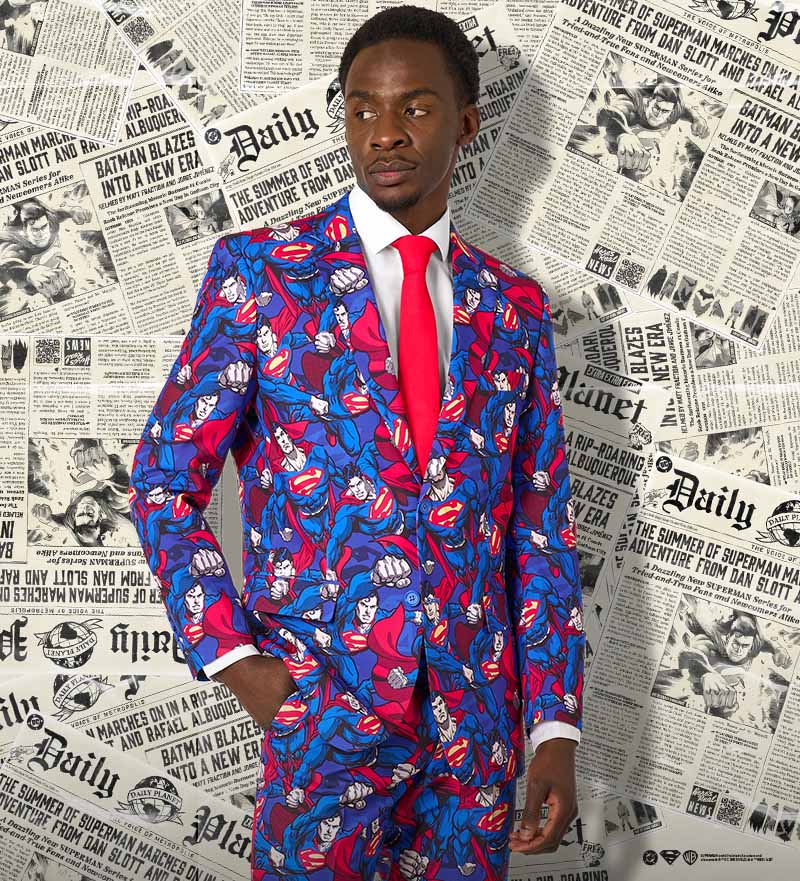 A men wearing a superman themed suit with a red tie and newspapers as a background