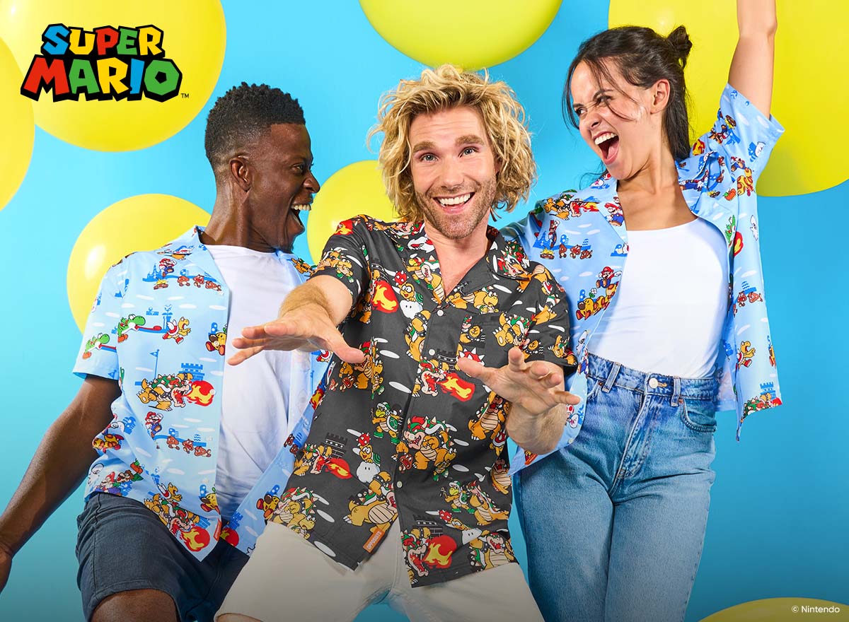 Three people wearing colorful Super Mario print shirts pose enthusiastically in front of a bright blue background with large yellow balloons. The Super Mario logo appears in the top left corner.