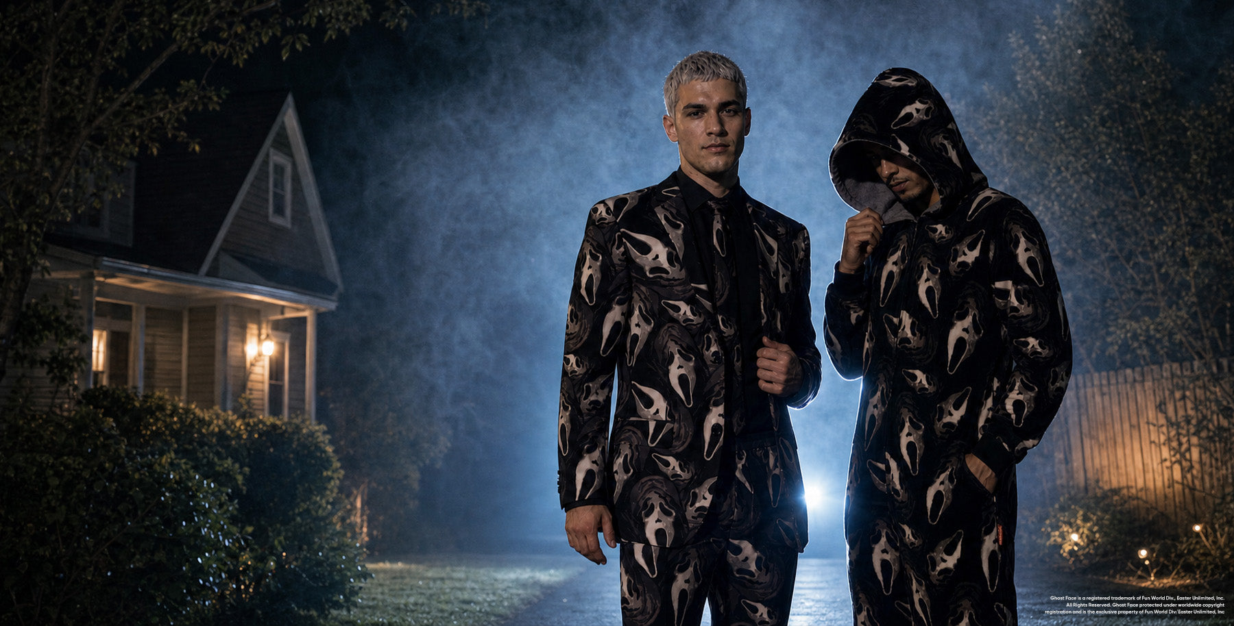 Two men wearing matching black-and-beige Ghostface-patterned outfits stand outside a house at night, surrounded by mist, trees, and dramatic blue backlighting.