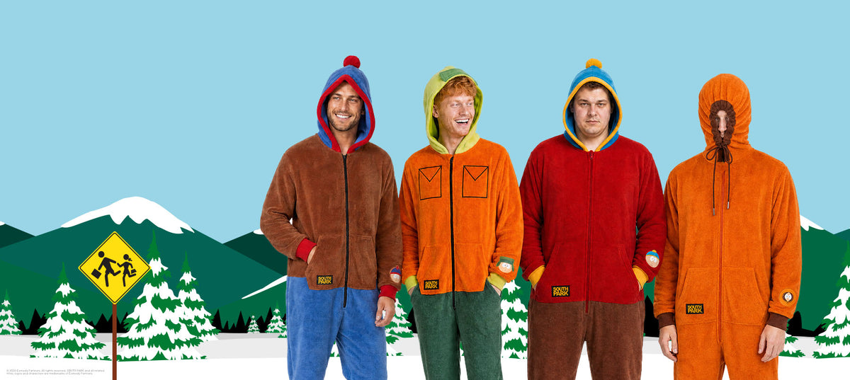 Four men wearing colorful South Park character onesies inspired by Stan, Kyle, Cartman, and Kenny, standing in front of a snowy South Park mountain backdrop.