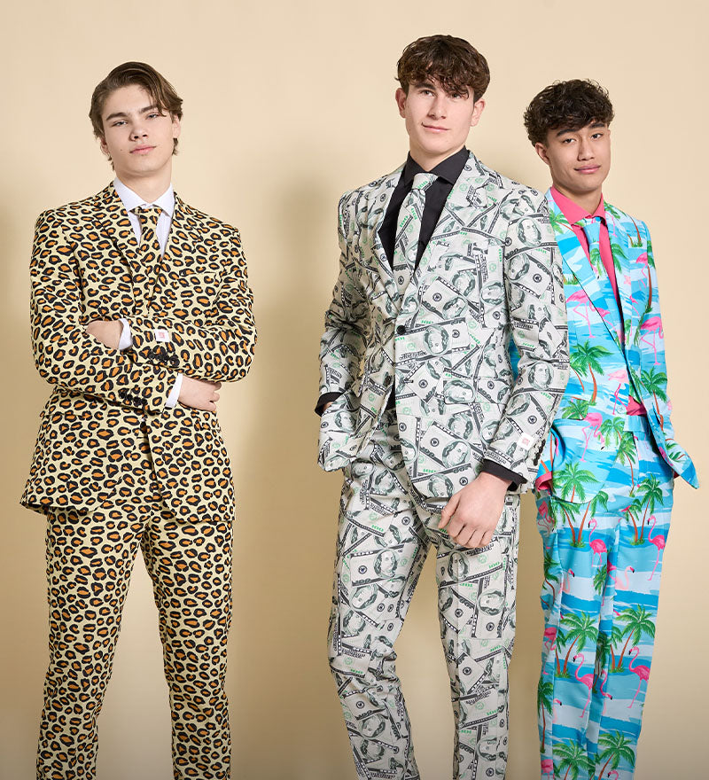 Image with yellow background and 3 men wearing all-over print suits. On the left a man wearing a panther print suit, in the middle a man wearing a money suit and on the right a man wearing a light blue palm tree suit.