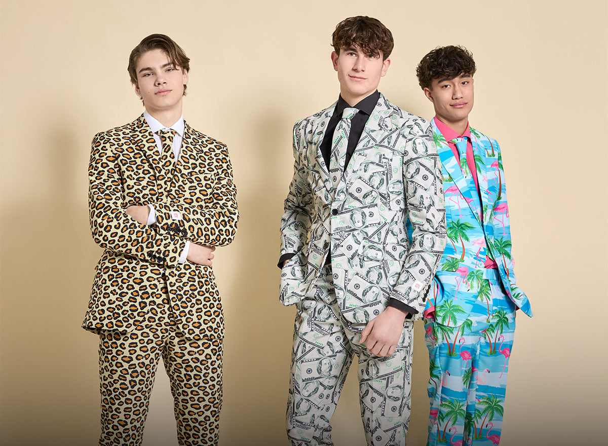 Image with yellow background and 3 men wearing all-over print suits. On the left a man wearing a panther print suit, in the middle a man wearing a money suit and on the right a man wearing a light blue palm tree suit.
