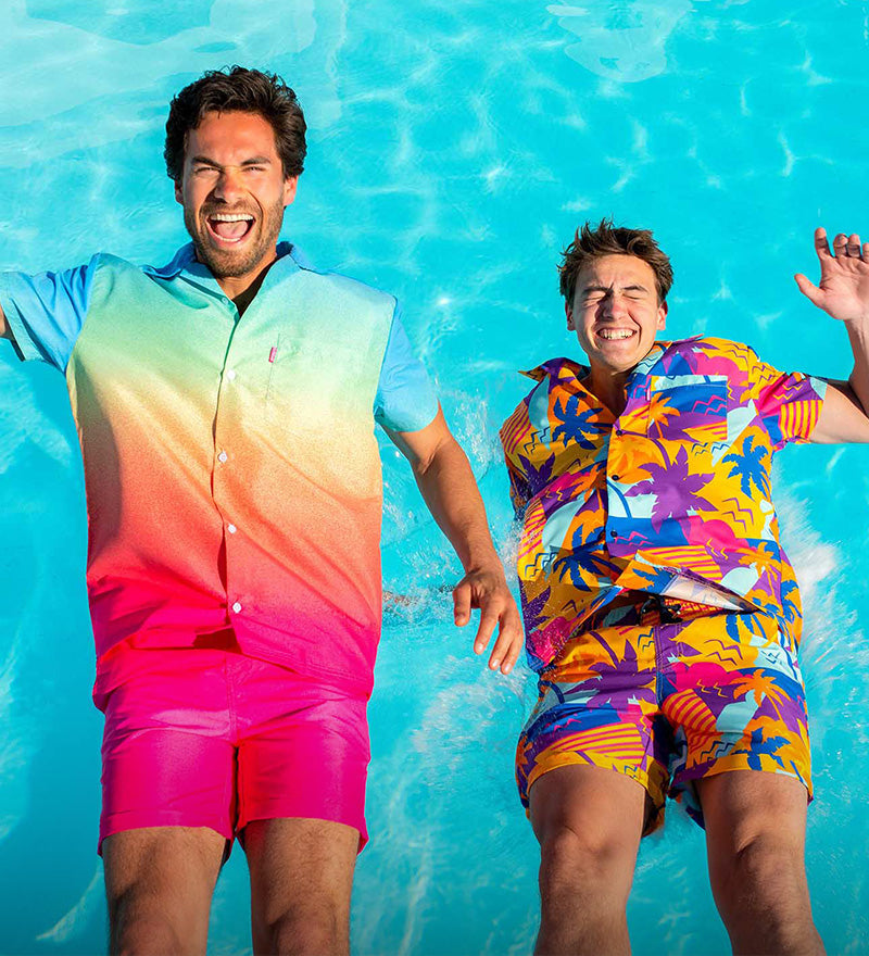 Two men falling in the swimming pool wearing colorful summer sets from OppoSuits.