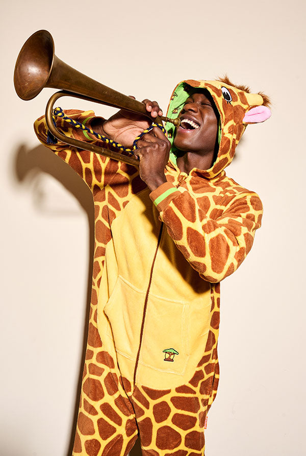 image with a man wearing giraffe onesie and he is playing trompet.