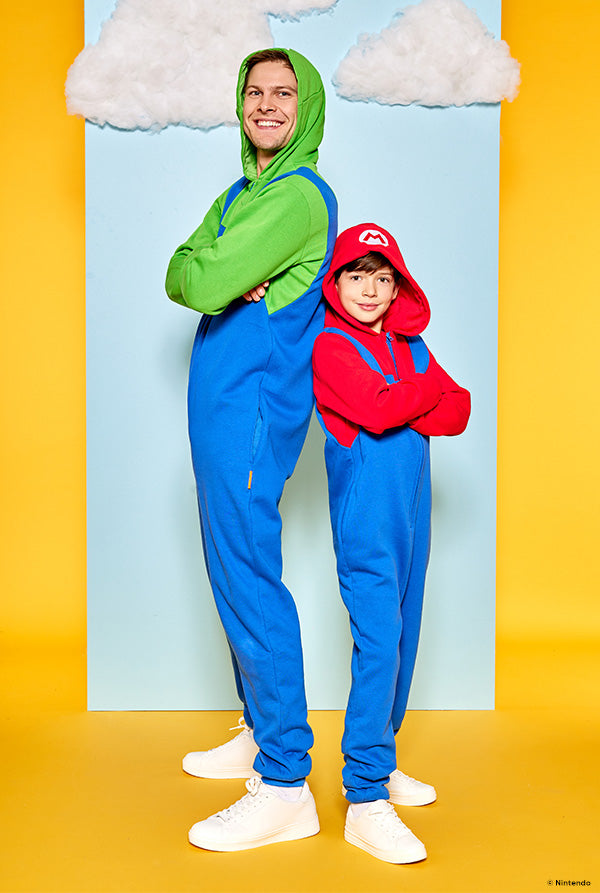 Image with yellow and blue background and kid and man wearing Mario and Luigi onesie.