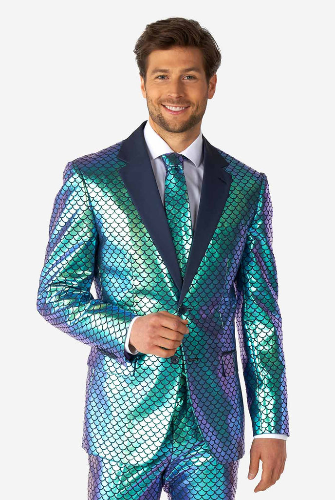 Video of man wearing Fancy Fish blue men's suit with shiny fish scale print, showing suit like a model. Suit consists of blazer, pant and tie.